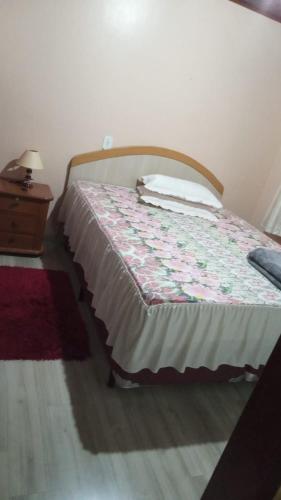 Bett in einem Zimmer mit einem Bettröckchen in der Unterkunft AMPLA CASA CONFORTAVEL NO GUARUJA CASCAVEL in Cascavel