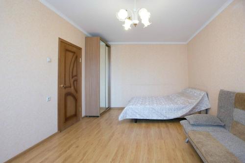 モスクワにあるDearHome Morshanskayaのベッド1台、ソファ、ドアが備わる客室です。