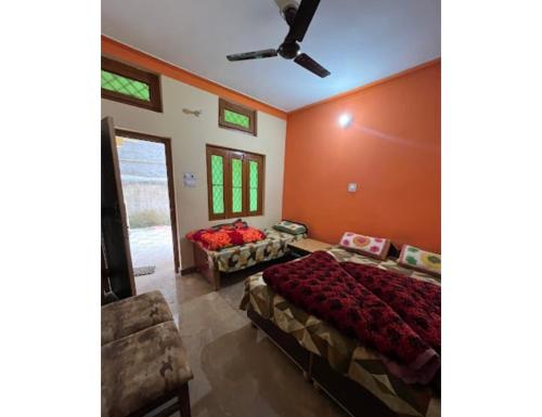 Hotel Vijaya, Dhar Gaon, Phata في Phata: غرفة نوم بسريرين ومروحة سقف