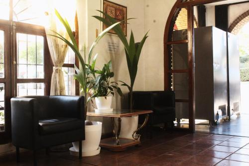 a lobby with a chair and a table with plants at SunDos Feria Valencia in Valencia