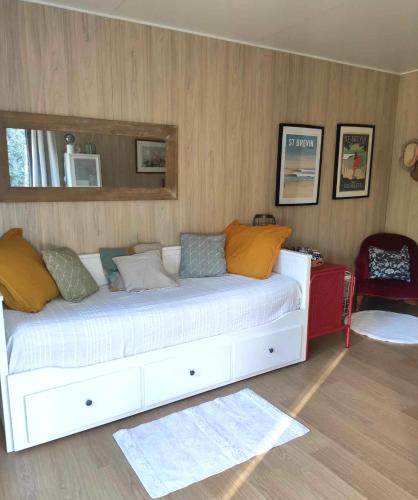 een slaapkamer met een groot wit bed met kussens bij La petite cabane de Georges à Saint Brévin l'Océan in Saint-Brevin-les-Pins