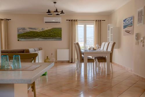 ein Esszimmer und ein Wohnzimmer mit Tisch und Stühlen in der Unterkunft Dina Apartments Argostoli in Argostoli