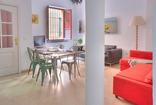 un soggiorno con tavolo da pranzo e sedie di Apartamento Torre de la Plata a Siviglia