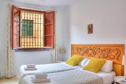 una camera con due letti e una finestra di Apartamento Torre de la Plata a Siviglia