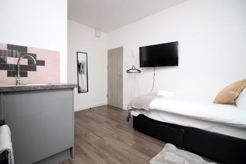 Habitación de hotel con cama y lavabo en Cohost Partners | Smart TV | 5 Min City | Parking, en Cardiff
