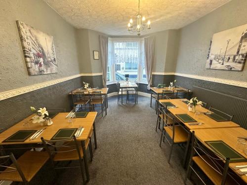 a dining room with wooden tables and chairs at Greenmount Guest House - Pet Friendly - Central to Everything - Everyone Welcome in Blackpool