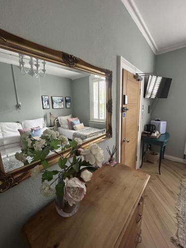 チェスターにあるMaison Claireの鏡と花のテーブルが備わる部屋