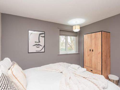 a bedroom with a white bed and a window at Pass the Keys Horsforth Haven on the banks of the River Aire in Pudsey