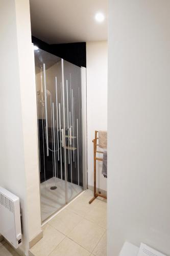 a bathroom with a shower with a glass door at la Ferme de Vazerat in Massiac