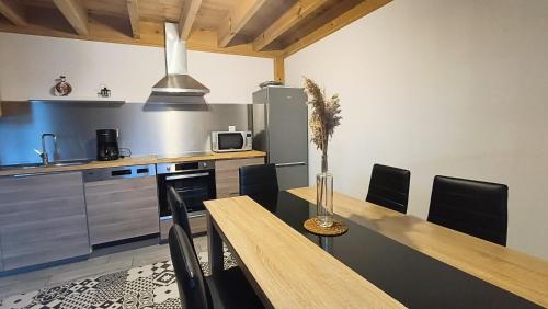 une cuisine avec une table, des chaises et un réfrigérateur dans l'établissement La maison d Irma à plage à 700 m, à Lanton