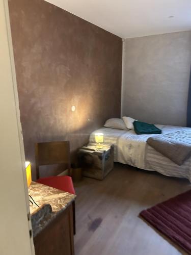 Dormitorio pequeño con cama y mesa en LA MARIEFACTURE - Comme du Bon Vin, en Sarreguemines