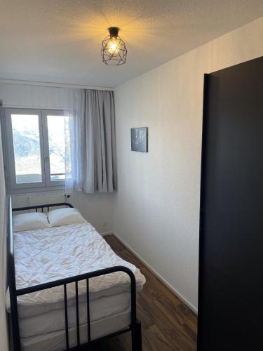 a small bedroom with a bed and a window at Fontanettaz V 014 - MOUNTAIN apartment 4 pers in Veysonnaz