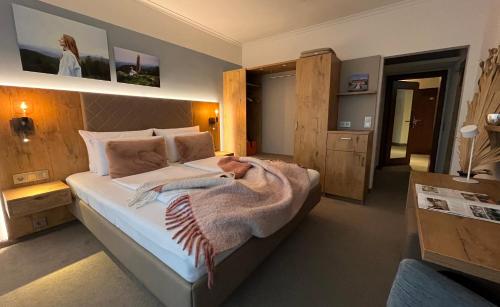 a bedroom with a bed with a dog laying on it at Hotel Schlossberg in Badenweiler