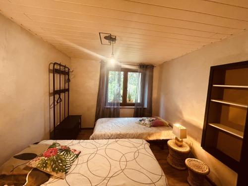 a small room with two beds and a window at LA MARIEFACTURE - Comme c'est Jungle in Hombourg-Haut