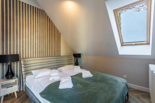 a bedroom with a bed with towels on it at Green Park Resort D28- z dostępem do basenu, sauny, jacuzzi, siłowni in Szklarska Poręba