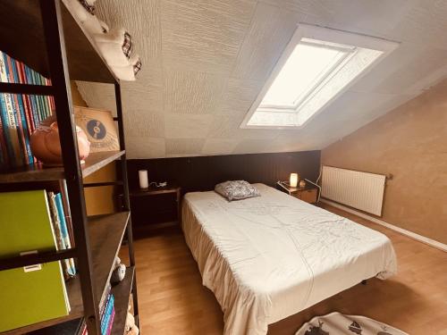 ein Schlafzimmer mit einem Bett und einem Dachfenster in der Unterkunft LA MARIEFACTURE - Comme à l'Ecole in Hombourg-Haut