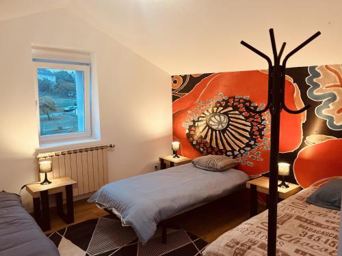 a bedroom with two beds and a painting on the wall at LA MARIEFACTURE - Comme une Fleur 