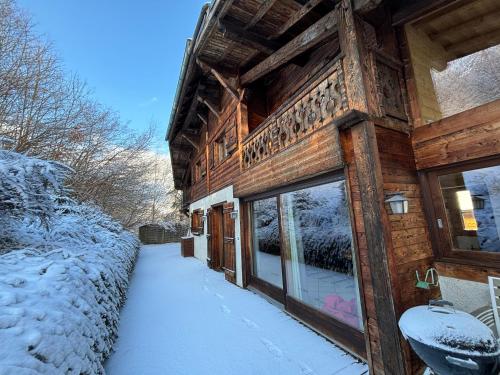 a log cabin in the snow with a snow covered sidewalk at Chalet Adonis - Montriond, Morzine, Avoriaz in Montriond