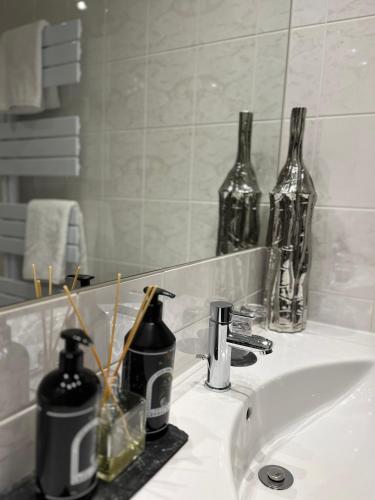 a bathroom sink with bottles on top of it at Hotel Schlossberg in Badenweiler