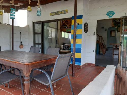 une salle à manger avec une table et des chaises en bois dans l'établissement Beach Cottage - Hole in the Wall Resort, à Hole in the Wall