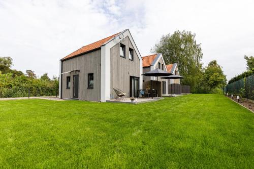 ein Haus mit einem großen Garten mit grünem Rasen in der Unterkunft Solo na wyspie, blisko morza Sobieszewo in Danzig