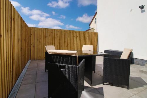 a patio with a table and chairs and a fence at Newport Road (FREE Parking) in Cardiff