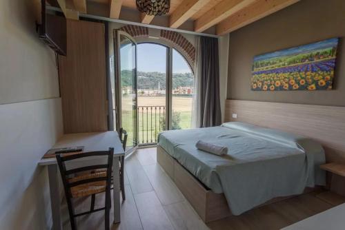 a bedroom with a bed and a table and a window at Tenuta da Rino - Agriturismo Barco Menti in Vicenza