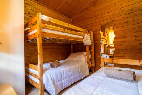 um quarto com 2 beliches num chalé de madeira em Italia Family Camping Village Viareggio em Torre del Lago Puccini