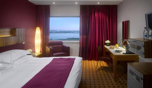 a hotel room with a bed and a desk and a window at Radisson Blu Hotel, Liverpool in Liverpool