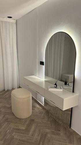 a white bathroom with a mirror and a white stool at شقة أنيقة غرفة وصالة بحي الملقا in Riyadh