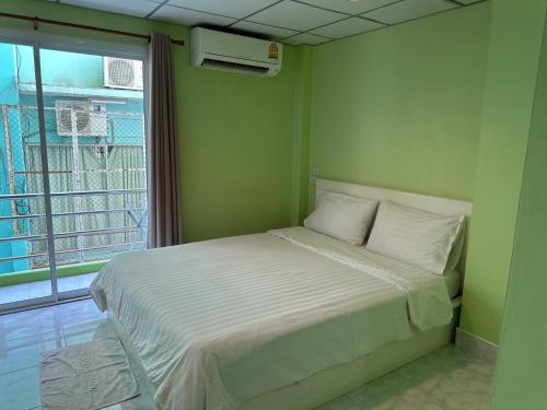 a bedroom with a bed in a room with a window at Baan Keang Talay Cha Am in Cha Am