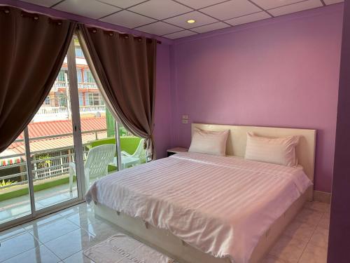 a purple bedroom with a bed and a large window at Baan Keang Talay Cha Am in Cha Am