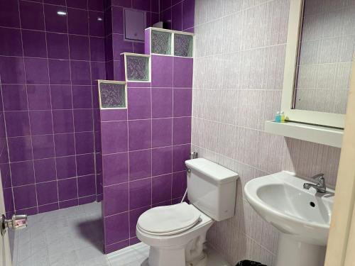 a purple tiled bathroom with a toilet and a sink at Baan Keang Talay Cha Am in Cha Am