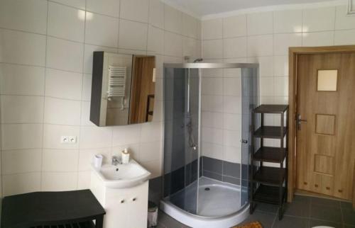 a bathroom with a sink and a shower and a toilet at Makadamia Karpacz in Karpacz