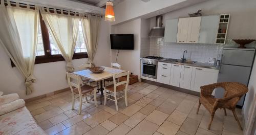 a kitchen with a table and chairs and a kitchen with white cabinets at Agriturismo Iazzo Scagno in Martina Franca