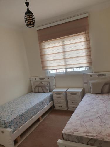 1 Schlafzimmer mit 2 Betten und einem Fenster in der Unterkunft Apparemment propre in Tangier