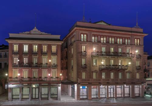 a large building in a city at night at Hotel Belvedere San Gottardo in Verbania