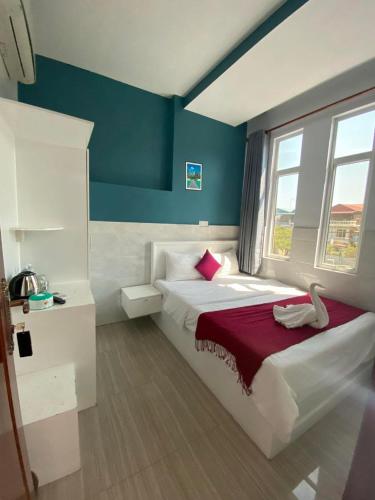 a bedroom with a white bed with a red blanket at Green Garden Guesthouse in Kampot