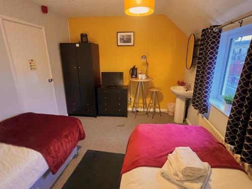 a bedroom with two beds and a sink in it at The Horse & Jockey in Gainsborough