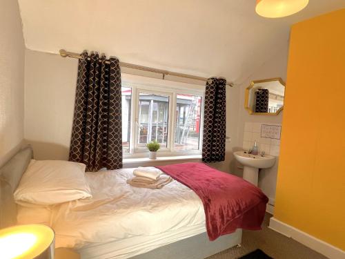 a bedroom with a bed and a sink and a window at The Horse & Jockey in Gainsborough