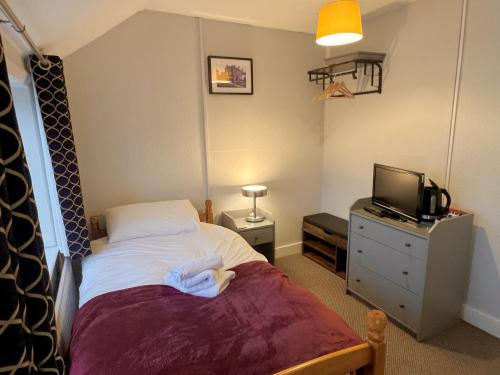 1 dormitorio con cama y vestidor con TV en The Horse & Jockey, en Gainsborough