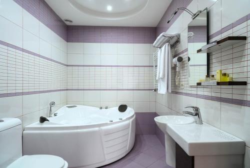 a bathroom with a tub and a toilet and a sink at Alpina Resort by Stellar Hotels, Tsaghkadzor in Tsaghkadzor