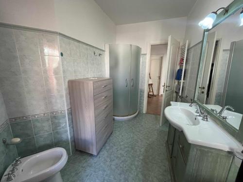 ein Badezimmer mit zwei Waschbecken, einer Dusche und einem WC in der Unterkunft Casa Vacanze Estate Al Mare in Tortolì