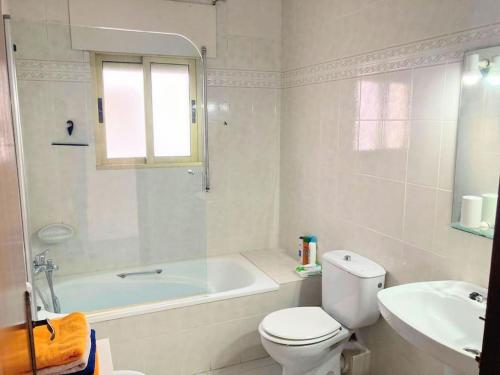 a bathroom with a toilet and a tub and a sink at Casa Cristina in Vinarós