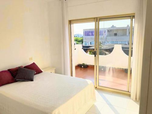 een slaapkamer met een bed en een groot raam bij Casa Cristina in Vinarós