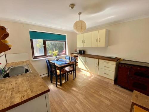 een keuken met een tafel en stoelen in een kamer bij Camp Hillcrest, flat, 