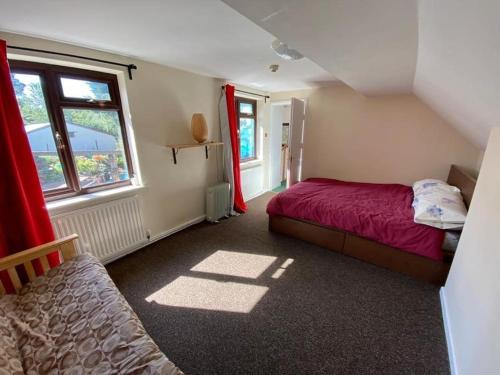 een kleine slaapkamer met een bed en een raam bij Camp Hillcrest, flat, 