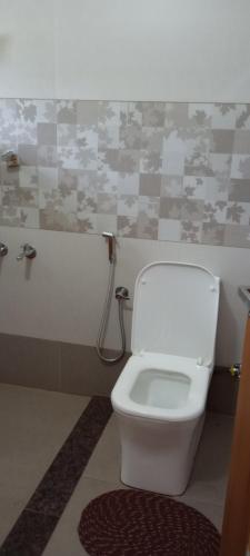 a bathroom with a white toilet in a room at Waterfront Family Homestay ( Jameela Manzil). in Murinjupuzha
