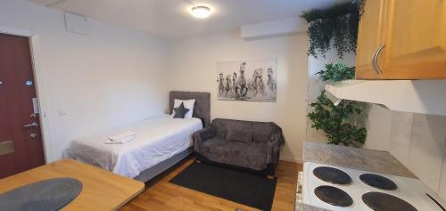 a small room with a bed and a chair at Studio apartment near metro and forest! in Stockholm