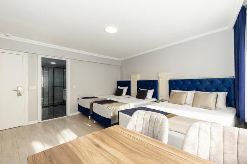 Habitación de hotel con 2 camas y mesa en Sirkeci Grand Family Hotel & SPA, en Estambul